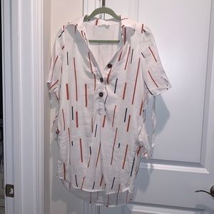 Collared white short sleeve top with orange and navy design by Lush